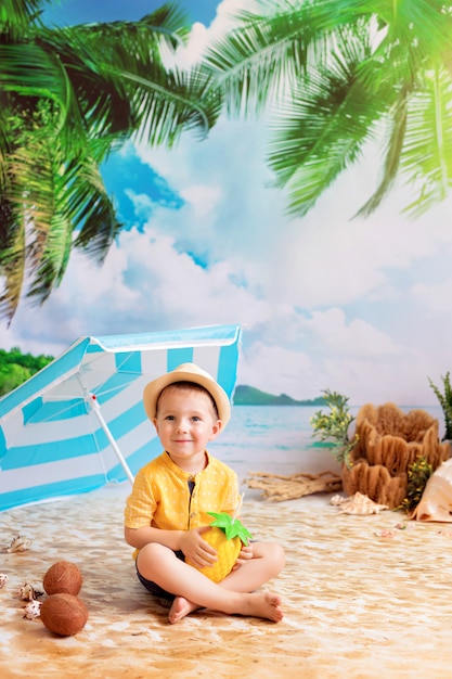 jongen in een zwembroek zonnebaadt op een zandstrand met palmbomen aan zee onder een parasol