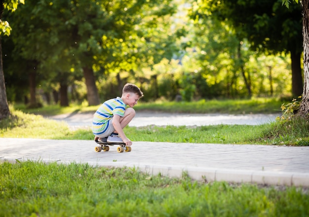 Jongen in gehurkte positie op een skateboard in het park