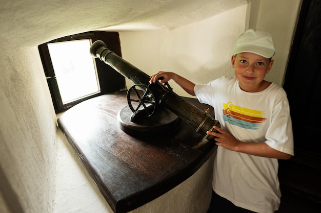 Jongen in het kasteel met een kanon