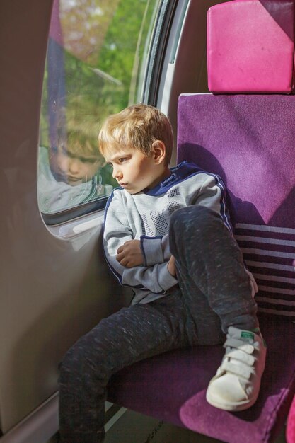 Foto jongen in het zonlicht op de trein ontbreekt gadgets reflectieve digitale gratis