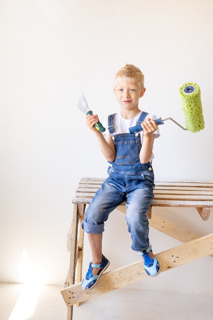 Jongen in jumpsuit schilderij roller te houden