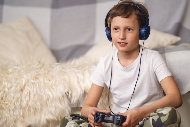 jongen in koptelefoon met een joystick in zijn handen spelen van videogames