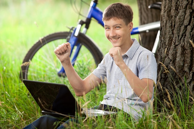 Jongen in park met laptop