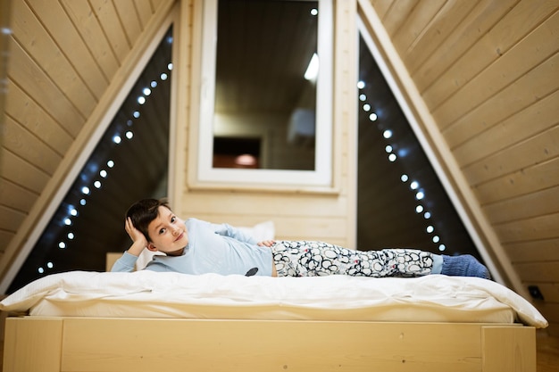 Jongen in pyjama spelen bij houten hut thuis Concept van geluk in de kindertijd vrijetijdsbesteding