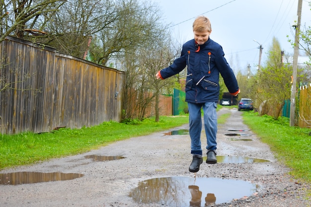 jongen jongen springen in een modderpoel