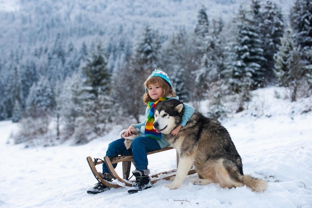 Jongen kind geniet van een slee rit kind op slee kind speelt buiten in de sneeuw wintervakantie en ch