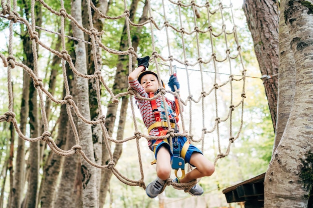 Jongen klimmen op een gladiatorgaas in een avonturenpark