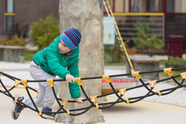 jongen klimt een touwladder in park