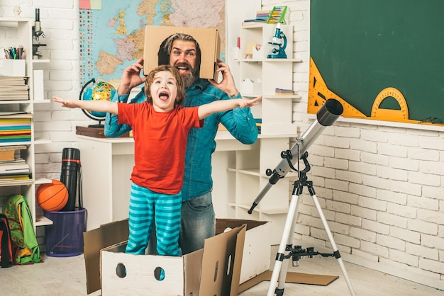 Foto jongen leerling astronoom met vader spelen met telescoop opgewonden leren