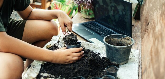 Jongen leert bloemen te kweken in het concept van vrijetijdsactiviteiten in potten