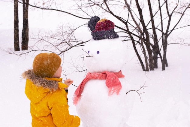 Jongen maakt sneeuwpop in park