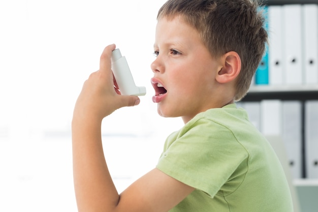 Jongen met behulp van een astma-inhalator