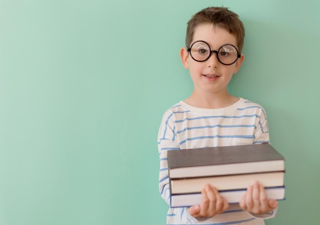 Jongen met bril houdt boeken vast