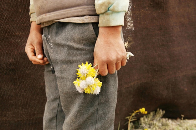 Jongen met gele bloemen armoede