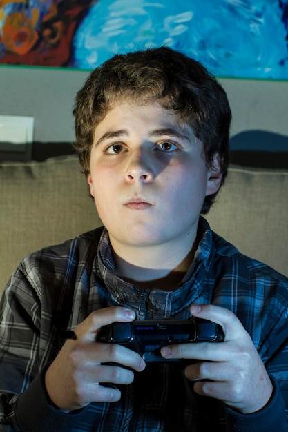 jongen met joystick die thuis een computerspel speelt.