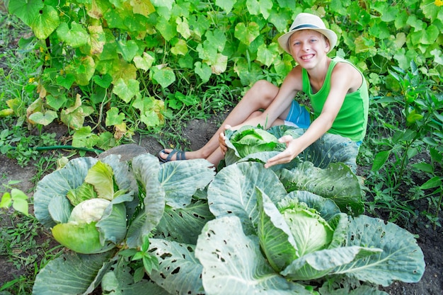 Jongen met kool in de tuin