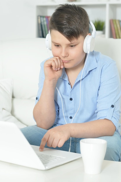 jongen met koptelefoon die laptop gebruikt