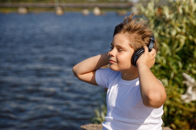 Jongen met koptelefoon luisteren naar muziek buitenshuis