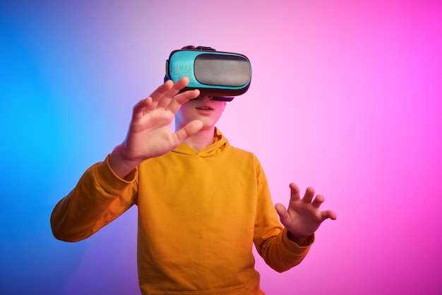 Jongen met virtual reality-bril op de kleurrijke muur. toekomstige technologie, vr-concept