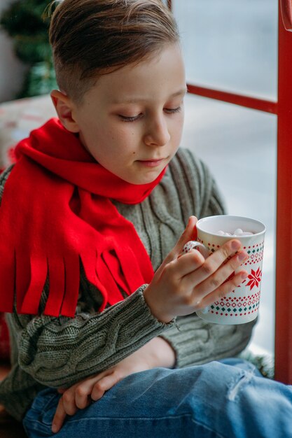 jongen met warme drank in Kerstmis