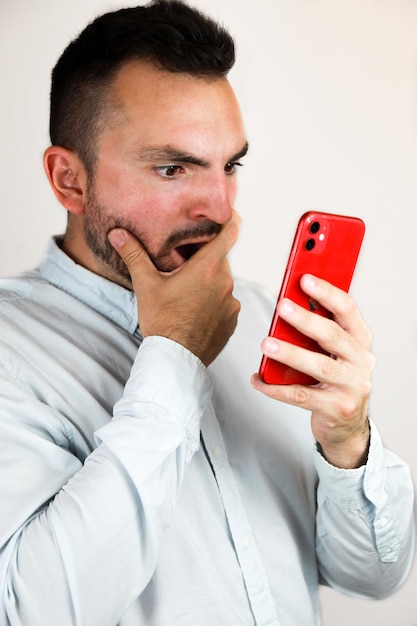 Jongen met zijn rode mobiele telefoon verrast om een schokkend nieuwsbericht te lezen over de linkshandige dag