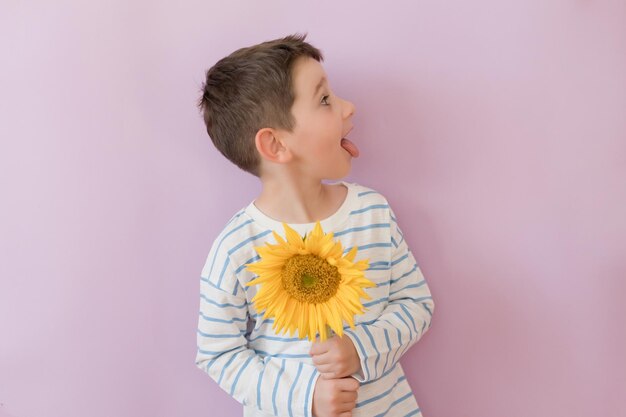 Jongen met zonnebloem op roze achtergrond