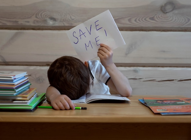 jongen moe van het doen van huisonderwijs aan tafel