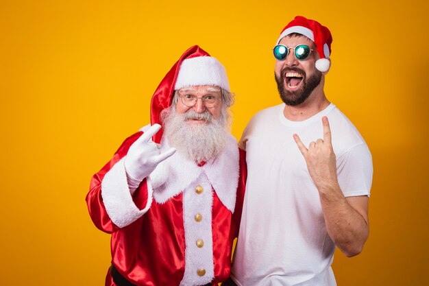 Jongen naast de Kerstman die rock-in-roll-teken maakt. De kerstman is een rocker