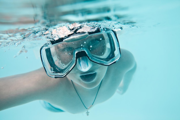 jongen onder water in zwembad op een blauwe achtergrond