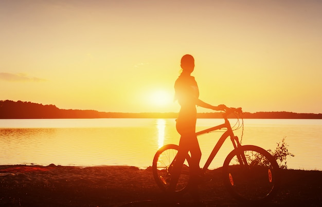 Jongen op een fiets bij zonsondergang