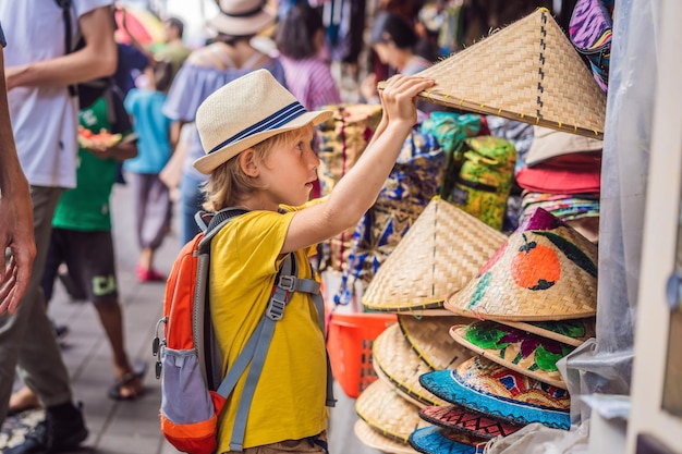 Jongen op een markt in Ubud Bali Typische souvenirwinkel die souvenirs en handwerk van Bali verkoopt op de beroemde markt van Ubud Indonesië Balinese markt Souvenirs van hout en ambachten van lokale bewoners