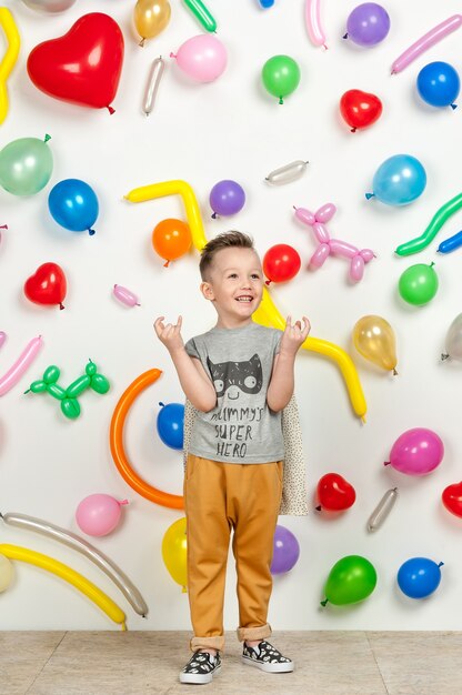 Jongen op een witte achtergrond met kleurrijke ballonnen