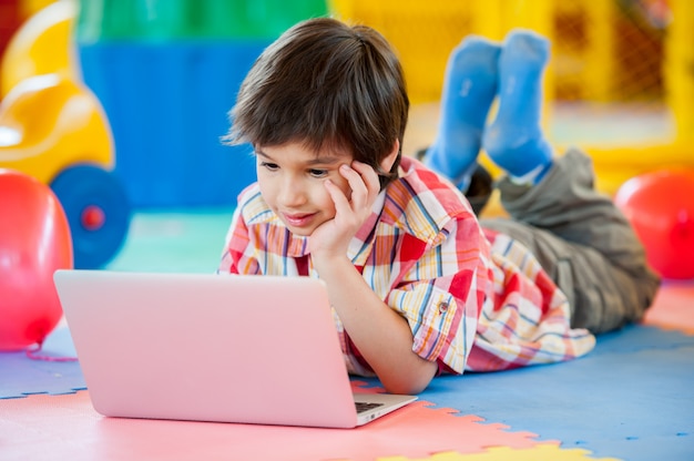 Jongen op laptop op speelplaats