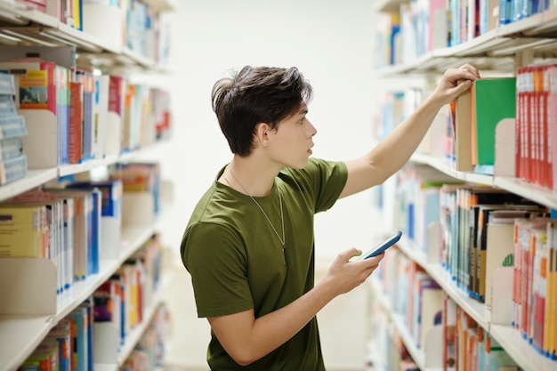 Jongen op zoek naar boek in bibliotheek