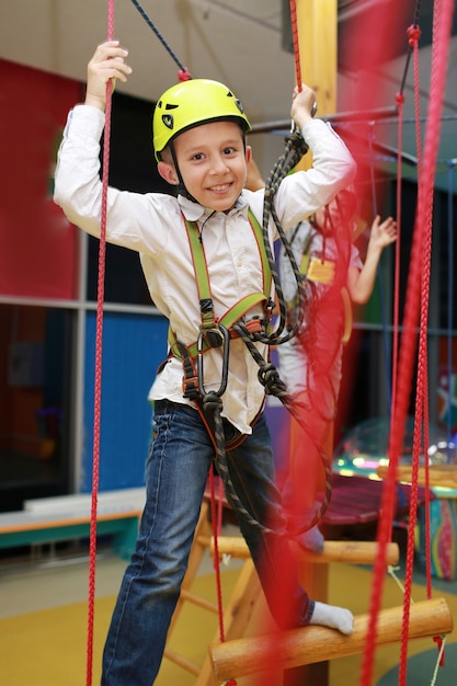 Jongen passeert een hindernisbaan, kabelbaan. Animatiecentrum voor kinderen.