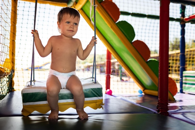 Jongen rijdt op een schommel in een speelkamer op een zomerdag