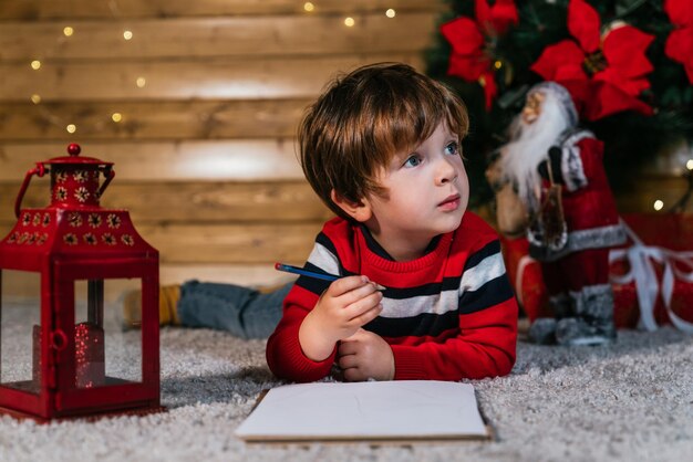 Foto jongen schrijft de brief aan de wijzen met kerstmis