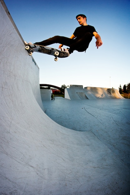 Jongen skateboarden in een skatepark in de middag