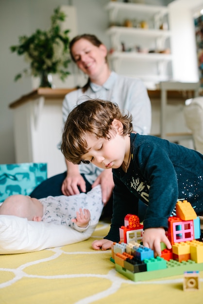 Jongen speelt met bouwstenen thuis op de vloer