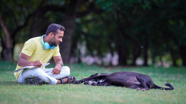 Jongen speelt met hond die in het park zit