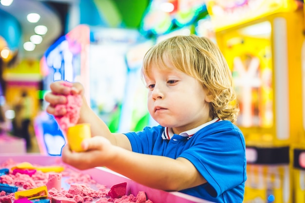 Jongen speelt met kinetisch zand in de kleuterschool