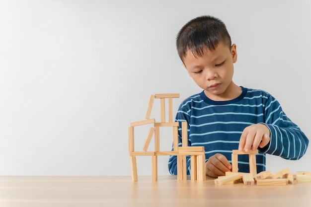 Jongen speelt thuis met houten blokken