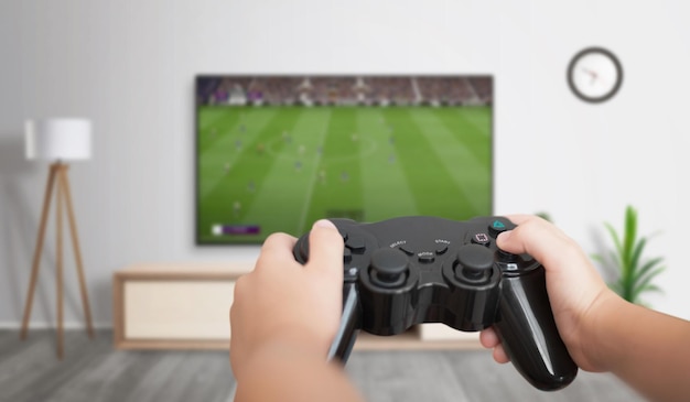 Jongen speelt voetbalspel op gameconsole op grote tv in woonkamer