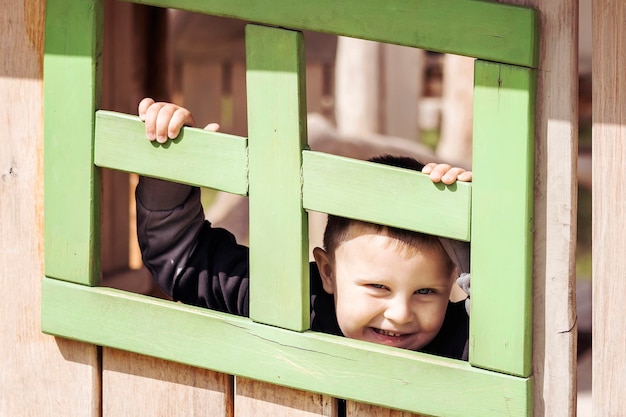 Jongen spelen, kind veel plezier op de speelplaats. gelukkige jeugd. buiten spelen op kinderspeelplaats