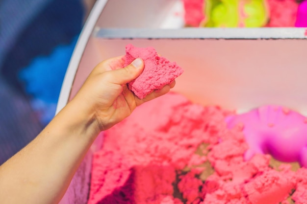 Jongen spelen met kinetisch zand in de kleuterschool. De ontwikkeling van het fijne motorische concept. Creativiteit Spelconcept