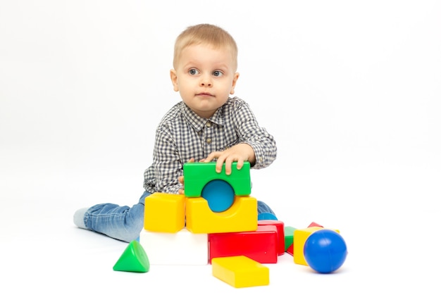 Jongen spelen met plastic speelgoed witte achtergrond geïsoleerd.