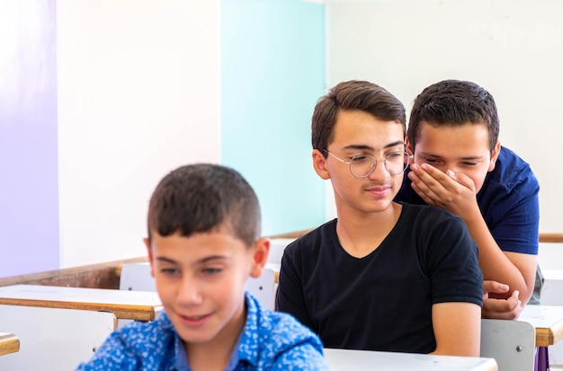 Jongen studeert op school met zijn collega's