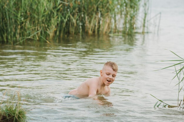 Jongen swimmimg in het meer. Zomervakantie. Zachte focus