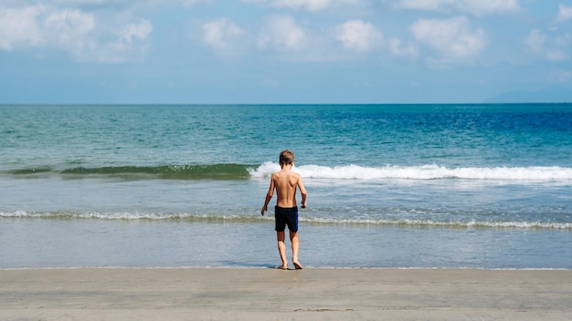 Foto jongen terug blauw kalm zee zon hemel achtergrond universum mogelijkheden zijn onbeperkt stap vooruit