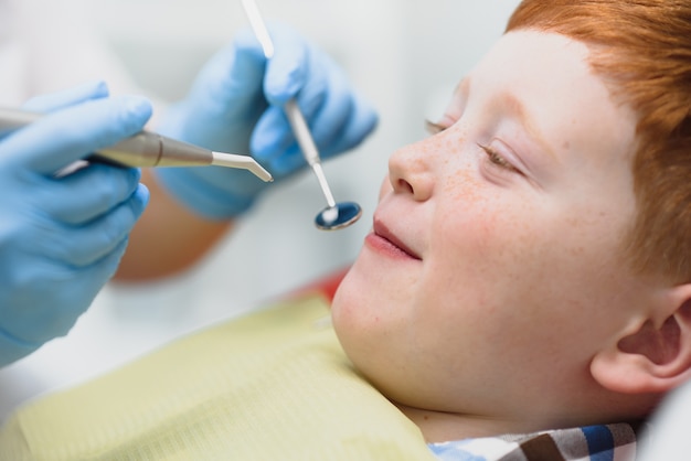 Jongen tevreden met de dienst in de tandartspraktijk. concept van pediatrische tandheelkundige behandeling